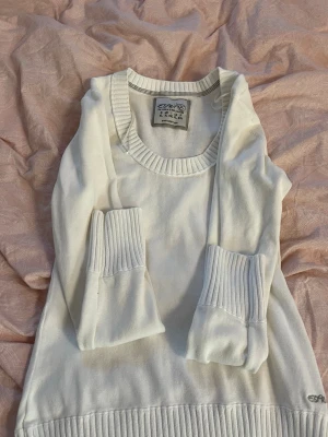 Vit stickad tröja från Esprit - Snygg vit stickad tröja från Esprit med bred ribbstickad mudd vid ärmslut och nederkant. Tröjan har rund halsringning och diskret broderad logga på ena ärmen. Perfekt för lager-på-lager och enkel att matcha. Den är extremt liten i storleken och passar s,m