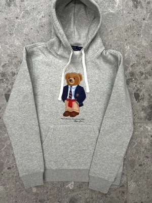 Polo bear hoodie herr, storlek S - Hej! Säljer denna riktigt schyssta polo bear hoodie från Ralph Lauren. Den är i storlek M men sitter en storlek litet och passar därför som en S. Den är endast använd någon enstaka gång och är därmed i ett nyskick. Original lappar och påse finns kvar och medföljer naturligtvis vid köp. Jag fraktar alltid snabbt!  Mvh