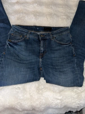 Tiger of sweden 29/30 - Snygga blå jeans från T/J med klassisk femficksdesign och raka ben. Jeansen har en mellanblå tvätt, kontrastsömmar och läderpatch med logga bak i midjan. Perfekta för en avslappnad och trendig look.