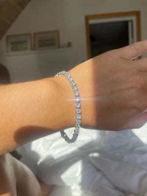Tennisarmband i äkta silver  - Ett vackert tennisarmband i äkta silver med glittrande kubisk zirkonia från Albrekts Guld. Ursprungspris 1699 kr. Mycket gott skick!