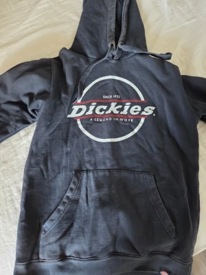 Mörkblå Dickies hoodie med tryck - Snygg mörkblå hoodie från Dickies med stort logotryck på bröstet och klassisk känguruficka. Huva med dragsko och mjukt material som känns skönt mot huden. Perfekt för en avslappnad streetwear-look.