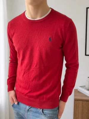 Röd Ralph Lauren tröja - Säljer en galet fet och unik Ralph Lauren tröja i färgen röd. Tröjan är i bra skick och är gjord i 100% Merino ull. Därav har den inga defekter och den sitter ungefär som en strl S-M men lite mer åt S håller, fast egentligen är den M. Hör gärna av er vid frågor eller funderingar!!