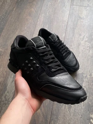  Valentino rockrunners sneakers - Säljer ett par riktigt snygga Valentino Rockrunners i färgen svart. Dessa är väldigt välkända och snygga. Skicket är 7/10 då lite nitar är av, men de är snyggt. Storleken är 43. Priset kommer ligga på 1099kr men kan sänkas.