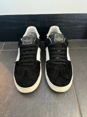 Valentino flycrews - Säljer dessa feta Valentino flycrews i svart mocka. Säljer då de är för små för mig.  Defekten på bild 5 syns bara om man trycker med fingret på skon annars syns det inte och ser ut som på bild 4. Sen syns defekten på bild 6 med att det är lite slitet på insidan av hälarna. Alla nitar är kvar. Hör av dig vid frågor /Mvh