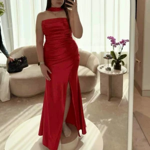 Röd långklänning med slits - ✨ Röd elegant klänning – perfekt till bal eller fest! ✨  Säljer en vacker röd klänning i glansigt, följsamt tyg som sitter perfekt och framhäver figuren på ett smickrande sätt. Draperad över byst och midja med en stilren slits framtill för en tidlöst elegant look.  Matchande långa handskar ingår.  🌹 Storlek: 38–40 🌹 Pris: 2200kr 🌹 Använd: Endast en gång, i nyskick 🌹 Passar till: Bal, fest, bröllop, nyår eller andra högtider  Kan provas/hämtas i Borås, köras till Göteborg eller skickas mot frakt