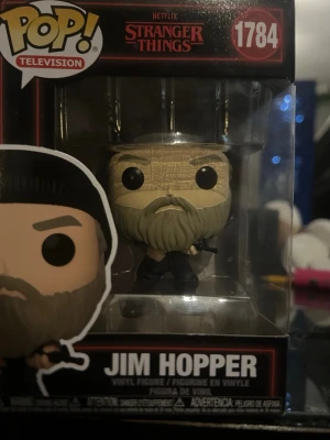 Funko Pop Jim Hopper Stranger Things - Cool vinylfigur av Jim Hopper från Stranger Things, modell 1784. Figurerad med skägg, keps och mörka kläder. Kommer i originalförpackning med Pop! Television-design. Perfekt för samlare eller fans av serien.