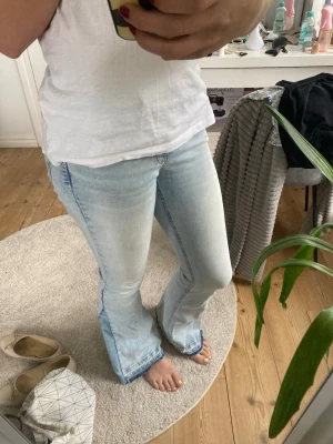 Ljusblå utsvängda jeans - Omsydda jeans från Gina, jag har sytt dom mer bootcut och sprättat upp dom så dom ska bli längre. Dom passar mig perfekt i längden men är lite svåra att stänga i midjan annars älskar jag dom!
