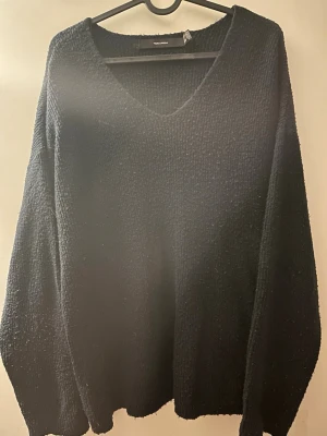 Marinblå stickad tröja Vero Moda - Mysig marinblå stickad tröja från Vero Moda med v-ringning och lång ärm. Tröjan har en enkel och stilren design som passar perfekt till jeans eller kjol. Materialet är mjukt och ger en avslappnad känsla.