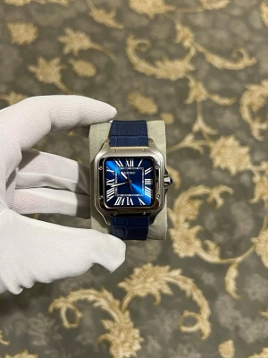 Seiko santos marinblå (Automatisk ) - Stilren klocka från Seiko med fyrkantigt silverfärgat boett, blå urtavla med romerska siffror och blått armband i läderimitation. Klockan har en modern design med tydliga detaljer och passar perfekt för dig som gillar klassisk men trendig stil.