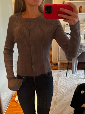 Ribbstickad grå kofta med knappar - Snygg grå kofta/topp. Jättefin till ett par jeans eller med en t-shirt