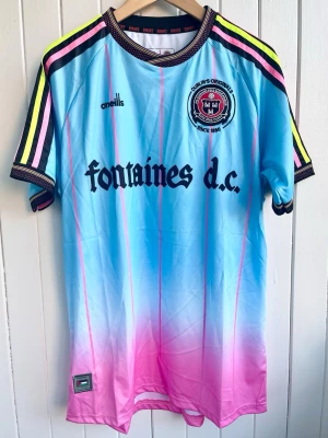 Fontaines D.C. - Merchandise - Fotbollströja - Säljer en Fontaines D.C-fotbollströja. Tröjan är en reprint i nyskick.   Storlek: Medium  #Pop #Rock #Music #Fashion #Sports #England #Oasis #Kent #Blur #Palestine