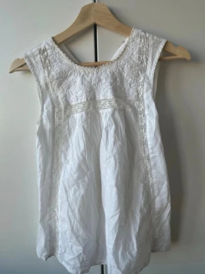 Vit blus med spetsdetaljer - Söt vit blus med spetsdetaljer och broderier framtill.  Perfekt för en fräsch och somrig look!🫧
