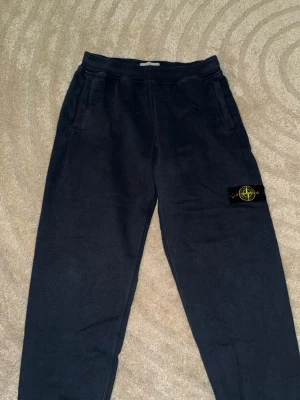 Svarta mjukisbyxor från Stone Island - Svarta mjukisbyxor från Stone Island med klassisk logopatch på benet. Byxorna har resår i midjan och två sidofickor. Perfekta för en chill och avslappnad stil. Knappt använda. 