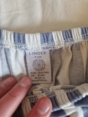 Of shoulder t-shirt från Lindex - En vit blå randig of shoulder t-shirt från lindex. Skön i tyget är nästan oanvänd har legat i min garderob ganska länge.