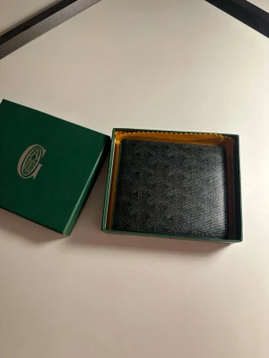 Svart mönstrad plånbok  - Snygg svart plånbok. Helt ny aldrig använd