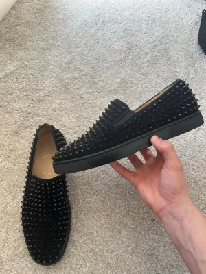 Christian Louboutin - Hej! Säljer dessa enligt mig sjukt feta Loubs slip ons med nitar som täcker hela skorna! Nästintill nya i skicket! Inga defekter, knappt några tecken på användning. Har till och med fabriksny doften kvar. Kostar 14k nya. Fräscha! 43,5 är storleken hör av sig vid minsta intresse av köp! 🙌