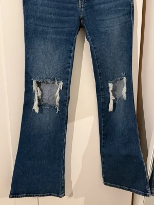 Low waist bootcut jeans med slitningar 💙 trendiga - Snygga blå low waist jeans med bootcut/flare passform och slitningar vid knäna 🔥 Ger en riktigt trendig Y2K vibe och sitter snyggt på kroppen.