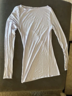  Ljuslila  intimissimi  - En enkel och stilren ljuslila långärmad topp från intimissimi i storlek S med rund hals. Tillverkad i mjuk bomull som känns skön mot huden. Perfekt att matcha med jeans eller kjol för en clean look.