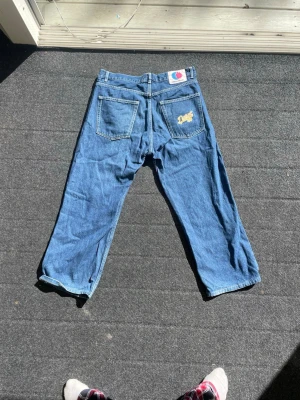 Blåa loose fit District 46,  - Säljer ett par klassiska blåa jeans från District 46 med rak och loose fit. Jeansen har två bakfickor, varav en med District logga, samt två framfickor. Tillverkade i slitstark denim och perfekta för en avslappnad streetwear-look.