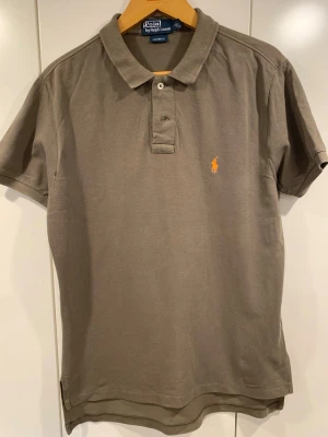 Olivgrön pikétröja från Ralph Lauren - Säljer denna riktigt snygga piké från Ralp Lauren, den är i relativt bra skick med lite små slitningar.
