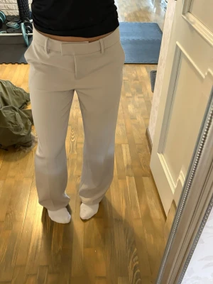 Beiga kostymbyxor  - Snygga beiga kostymbyxor med raka ben. Dom är ifrån bikok och har lite defekter, enstaka fläckar och små noppror, därav priset😚