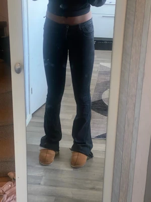 Svarta bootcut jeans med hög midja - Säljer ett par svarta bootcut jeans med hög midja och klassisk femficksdesign. Jeansen har en snygg utsvängd passform från knät och ner, vilket ger en trendig siluett. Perfekta att matcha med crop tops eller hoodies för en cool look. W29/L38