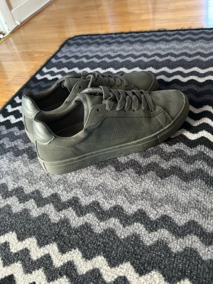 Svarta sneakers  - Snygga svarta sneakers med vita skosnören och sula. Klassisk låg modell med rund tå och diskret design som passar till det mesta. Perfekta för dig som vill ha en clean och stilren look till vardagsoutfiten.