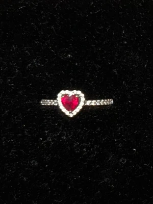 Pandora ring med rött hjärta  - Intr trasig - Perfekt att ge bort till nån man gillar - Är i Sterlingsilver - Nypris för denna är 800kr. Jag säljer för 400kr. Är det några frågor så fråga på!