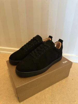 Svarta låga sneakers i mocka - Stilrena svarta sneakers i mocka med svart sula och svarta skosnören. Insidan är ljusbeige och skon har en klassisk låg profil. Perfekta för dig som gillar minimalistisk och clean stil.