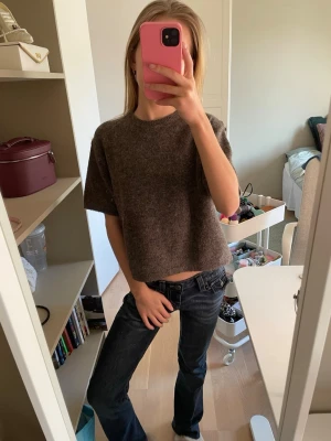 Brun stickad croppad topp - Grå stickad tröja i mjukt och skönt material. Den är något croppad med korta ärmar och har en enkel, stilren passform som funkar till det mesta. I fint skick den är ALDRIG använd  och perfekt till vardagliga outfits. Pris går att diskutera. Skriv om ni har frågor eller funderingar!! (Jeansen ni ser på bilden säljer jag även! Gå in och kollla in min profil!)💓😇😇