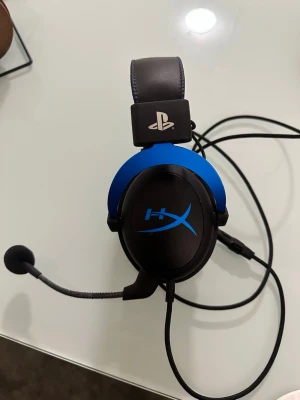 HyperX gamingheadset blå/svart - Snyggt gamingheadset från HyperX i blått och svart med PlayStation-logga på bygeln. Over-ear design med mjuka kuddar och justerbar mikrofon. Perfekt för gaming och voice chat. Kabelanslutning för stabil uppkoppling.
