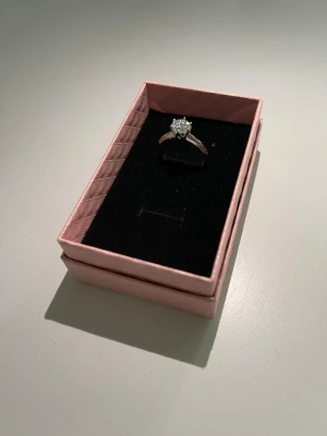 Moissanite Ring - Elegant moissanite-ring i 925 sterling silver med fantastisk lyster och exklusiv känsla ✨  💎 VVS1 Moissanite 💎 925 Sterling Silver 💎 Justerbar storlek – passar de flesta 💎 GRA-certifikat ingår 💎 Box medföljer  En stilren ring som passar perfekt både till vardags och fest. Moissanite är känd för sitt otroliga glitter och ger en lyxig look till ett mycket bättre pris än traditionella diamanter.  Helt ny och oanvänd.  Skicka gärna ett meddelande om du har frågor eller vill se fler bilder 😊