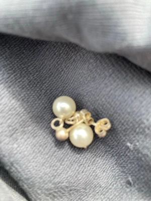 Silverörhängen med pärlor - Säljer ett par klassiska örhängen i äkta silver (stämplade 925) med vita pärlor. Stiftmodellen gör dem enkla att bära och de har en tidlös look som passar till många stilar. Perfekta för dig som gillar stilrena accessoarer.