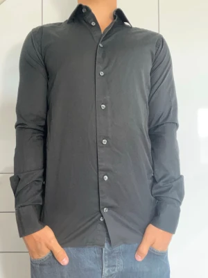 Svart skjorta från Eton - Svart skjorta från Eton i 100% bomull. Strl 38/S. Inga defekter. Modellen är 178 cm och väger 77 kg. Hör gärna av dig vid frågor!