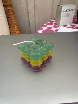 Färgglad bubbel-ljus i tre lager - Unik hjärt-ljus med tre lager i grönt, gult och lila. Ljuset har en kubformad design med runda bubblor av hjärta och är tillverkat av stearin. Perfekt som dekorativ detalj i hemmet eller som present till någon som gillar coola inredningsprylar. Finns i flera olika färger. Egengjorda.