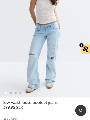 Ljusblå bootcut jeans med slitningar - Säljer ett par ljusblå jeans med låg midja och bootcut-ben. Jeansen har en loose fit och flera slitningar och hål på framsidan för en cool och avslappnad vibe. Klassisk femficksmodell och tillverkade i denim.