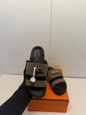 Herméss tofflor  - Säljer ett par extremt stilrena och exklusiva  Jackson sandaler. Denna modell kombinerar sportig komfort med tidlös lyx och är perfekt för sommaren eller semestern.Detaljer: Modell:Jackson Storlek: 41 Färg: Brun Material: Premium kalvskinn Hårdvara: Ikoniskt Kelly-lås. Kommer givetvis med originalbox (den klassiska orange lådan) samt dustbags.Nypris i butik ligger runt 12 000 - 15 000 kr.