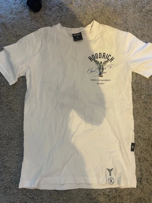 Vit Hoodrich t-shirt med ängeltryck - Säljer en vit t-shirt från Hoodrich med stort tryck av en ängel och texten 'From Nothing To Something' på ryggen. Köpt på JD sports för något år sedan och har knappt används så den är i inprincip nyskick