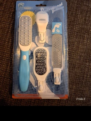 Pedikyrset med utbytbara filhuvuden - Pedikyrset med blått handtag och fyra utbytbara filhuvuden i metall och plast. Perfekt för att fila och ta bort förhårdnader på fötterna. Setet innehåller olika grovlekar för anpassad fotvård och ger mjuka och fräscha fötter.