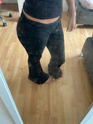 Svarta ribbade leggings med utsvängda ben - Säljer ett par svarta leggings med ribbad struktur och utsvängda ben. De har hög midja och sitter tajt upptill men blir vidare nedtill. Perfekta för dig som gillar en trendig och bekväm stil. Materialet ser stretchigt ut och passar till många olika outfits.