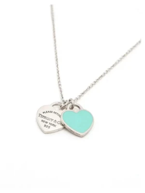 ALDRIG ANVÄNT Tiffany & Co. hjärthalsband i silver - Snyggt halsband från Tiffany & Co. i äkta silver med två hjärtformade berlocker, varav en är turkos och en har ingraverad text. Kedjan är tunn och stilren, perfekt för dig som gillar klassiska smycken med en modern touch. Ikonisk design från New York.