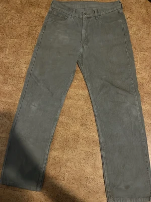 Gråa Levi's manchesterbyxor - Säljer ett par gråa manchesterbyxor från Levi's med klassisk rak passform. Byxorna har fyra fickor, bälteshällor och Levi's ikoniska läderpatch bak i midjan. Tillverkade i mjuk manchester som ger en retro och avslappnad vibe. Priset kan diskuteras 