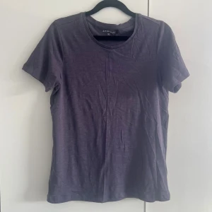 Lilagrå t-shirt  - En enkel och stilren lila t-shirt. T-shirten har rund halsringning och korta ärmar. Tillverkad i mjuk bomull som känns skön mot huden. Perfekt basplagg att matcha med jeans eller kjol. Endast testad 