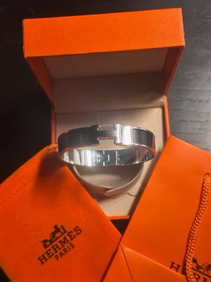 H armband - Snyggt armband från H och som är svart och silver,och som kommer med låda