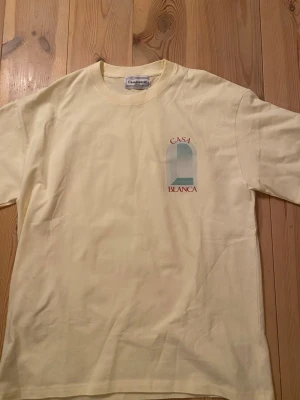 Gul t-shirt från Casablanca - Snygg ljusgul t-shirt från Casablanca med tryck på bröstet där det står 'Casa Blanca'. Klassisk rund hals och korta ärmar. Perfekt för dig som gillar stilrena plagg med en twist. Tillverkad i mjuk bomull för skön känsla. Tveka inte vid fråger