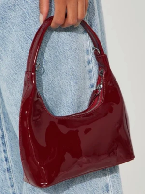 Vinröd väska - Snygg vinröd handväska i glansigt lackmaterial med kort axelrem och silverfärgade metalldetaljer. Helt ny, aldrig använd, kommer plastad och i orginalförpackning. 