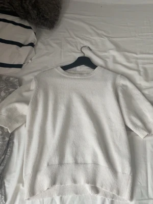 Vit stickad tröja från Dazy - Säljer en vit stickad tröja från Dazy i storlek S. Tröjan har rund hals, ribbade muddar och korta ärmar. Perfekt för lager-på-lager och passar dig som gillar enkel och clean stil💕💕