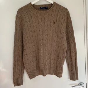 Ralph Lauren stickad tröja - Ralph Lauren Beige Cable-Knit Sweater. Storlek S. Tröjan är i fint skick utan defekter med en väldigt fin färg som passar bra till våren & hösten. Nypris var runt 2100 kr.