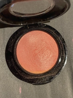 MAC shade new romance  - Krämrouge i en rund svart dosa med genomskinligt lock. Färgen är persikorosa med en lätt varm underton, perfekt för att ge kinderna en naturlig fräschör. Enkel att applicera och smälter fint in i huden för ett mjukt resultat.