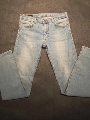 Ljusblå Slim jeans från J.Lindeberg W31 L34 - Säljer ett par ljusblå jeans från J.Lindeberg med klassisk femficksmodell och raka ben. Jeansen har en snygg tvättad look och är tillverkade i bomull. Perfekta för en avslappnad stil och passar till det mesta.